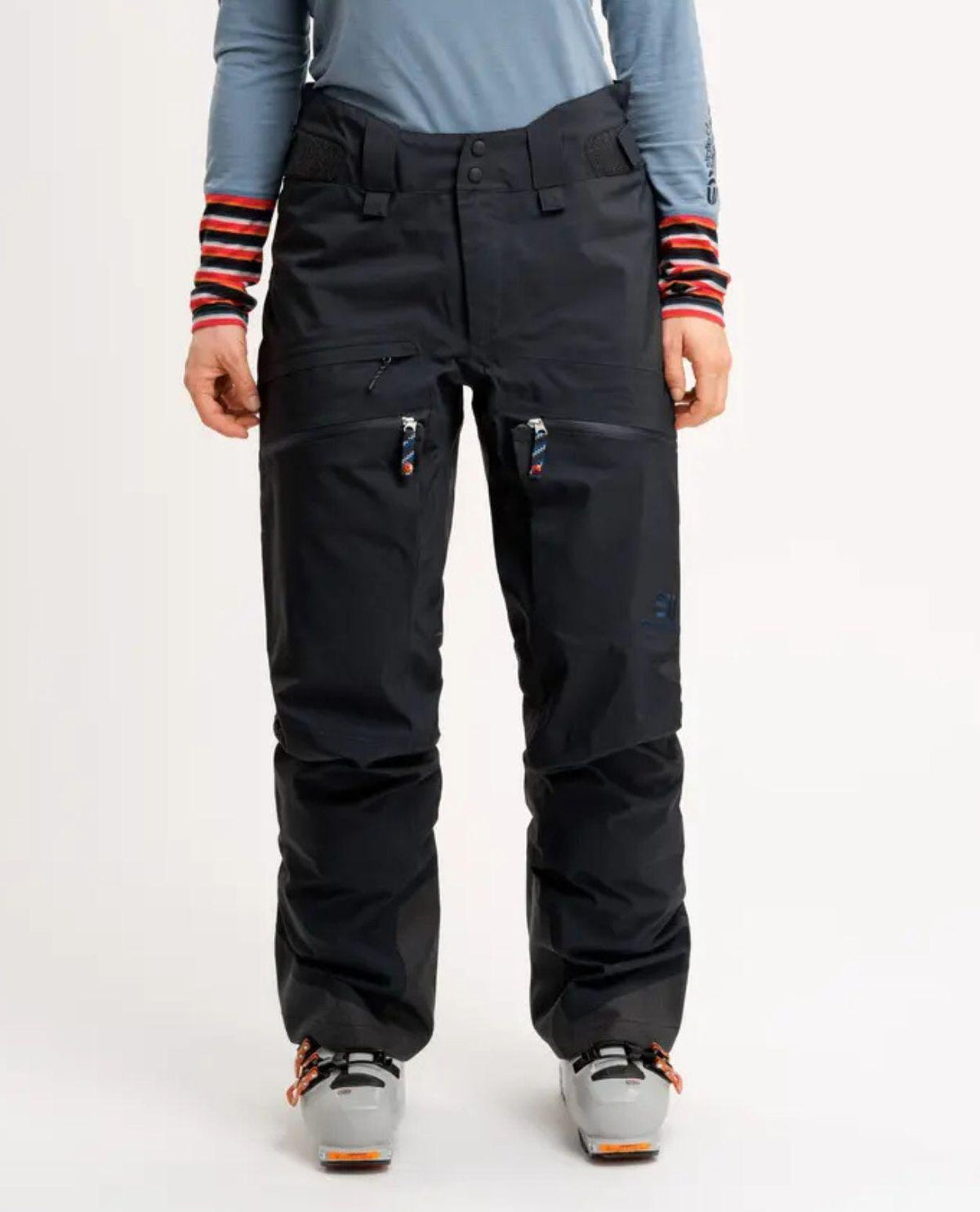 Elevenate Pure Pants Women i mörksvart färg framifrån, visande skidbyxornas passform, dragkedjor och förstärkta benslut.