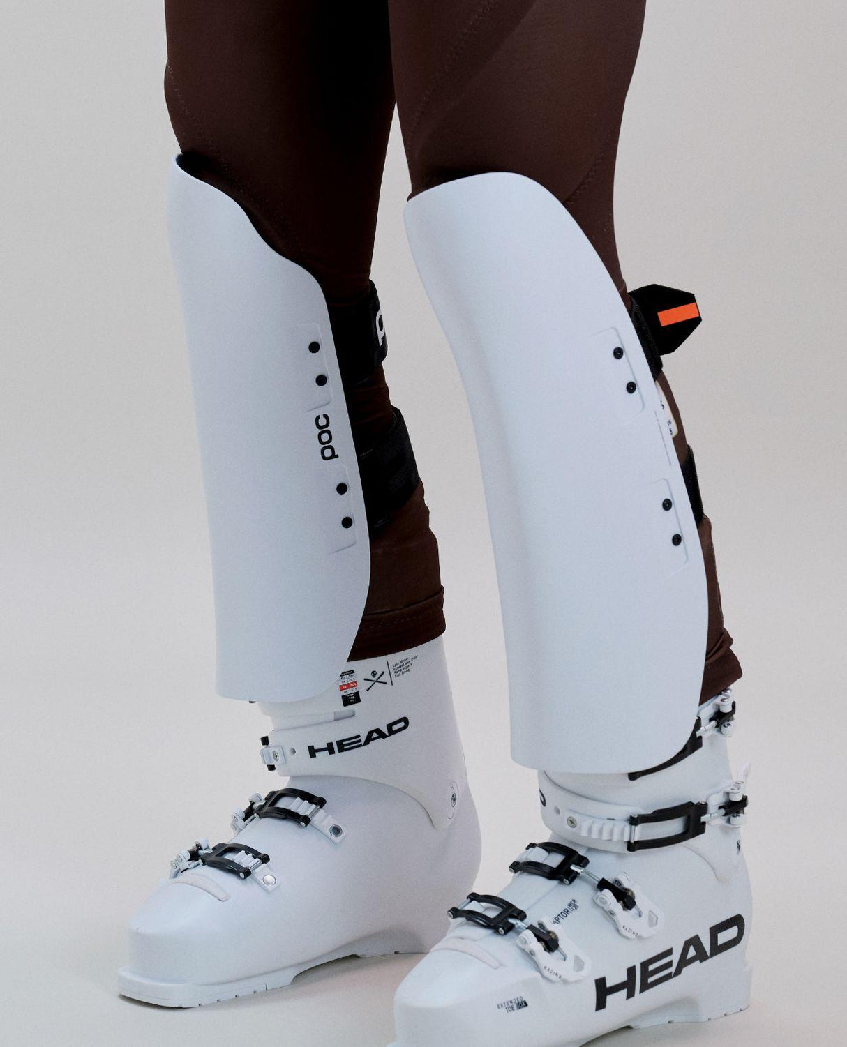 POC Shins Race benskydd i färgen Hydrogen White på skidåkare tillsammans med pjäxor.
