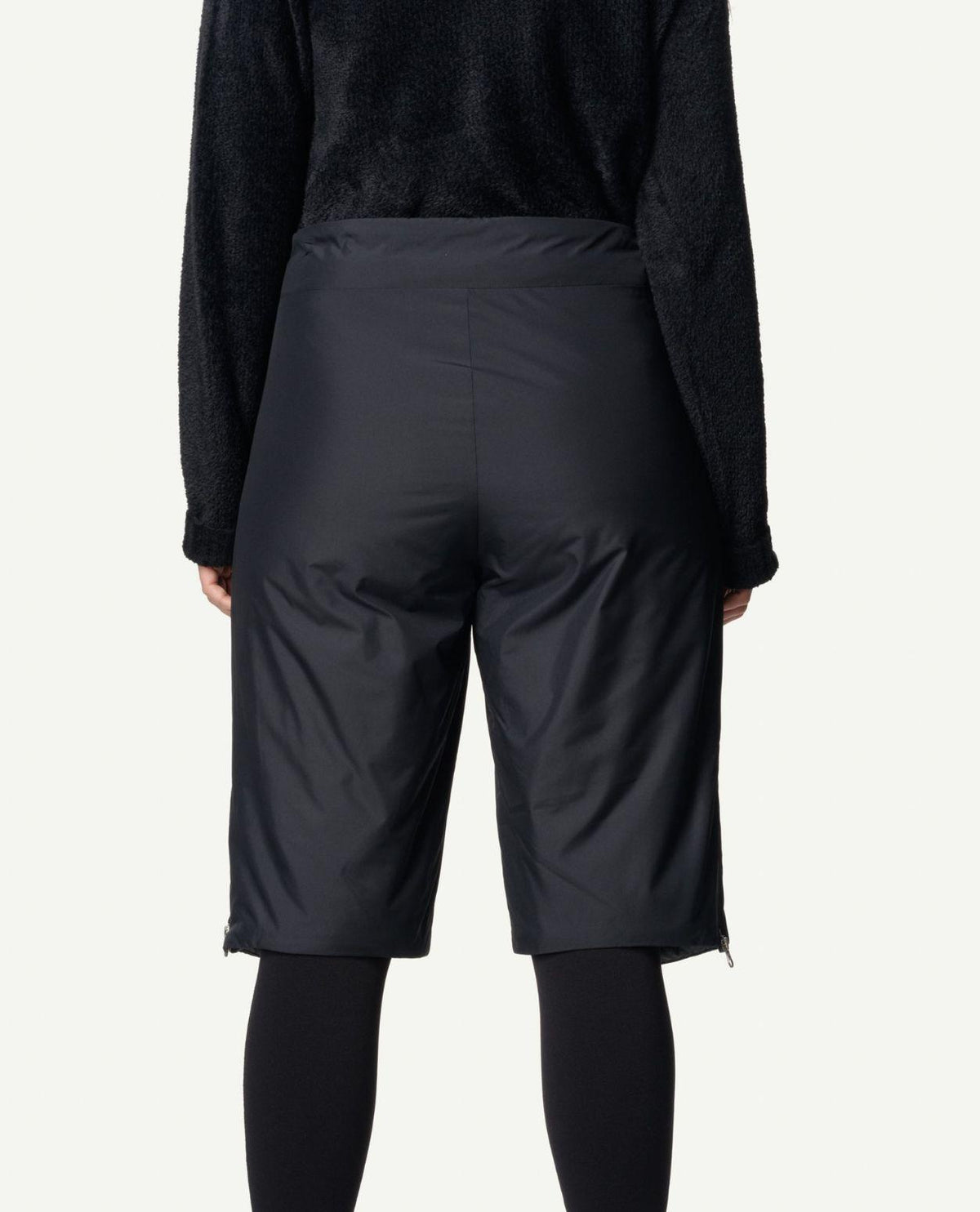 Baksidesvy av Houdini Dunfri Shorts dam i svart färg buren med tröja och tights.