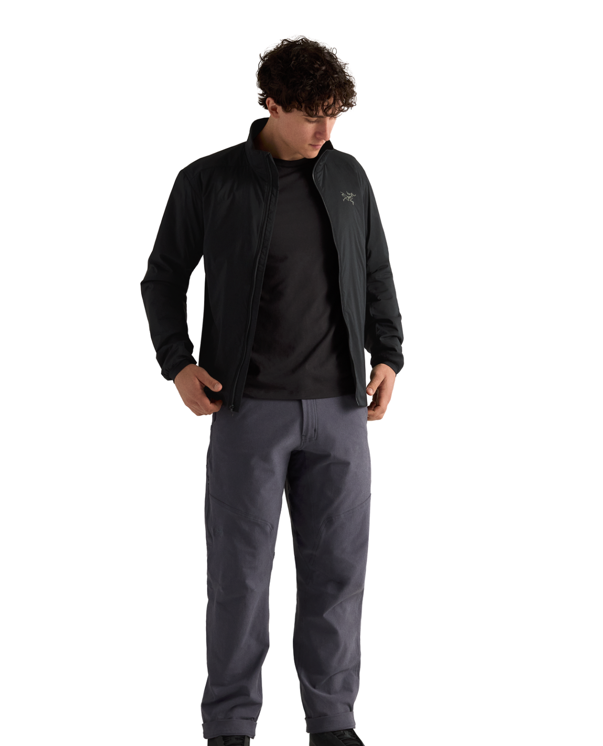Manlig modell som bär den svarta mellanlagersjackan Arc'teryx Atom Jacket Men mot vit bakgrund.