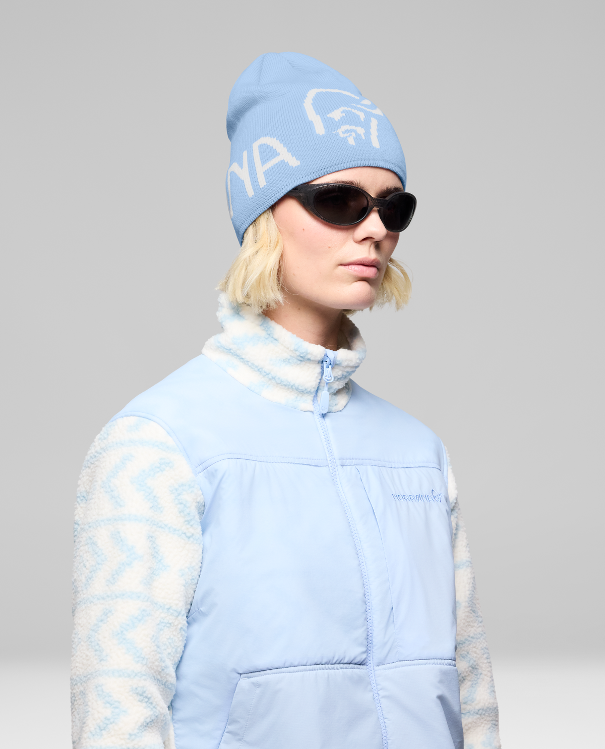 Norrøna /29 mid merinoUll Logo Beanie i färgnyansen Allure på modell med solglasögon. Alpingaraget