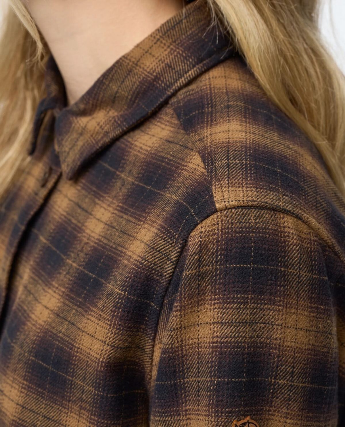 Fjällräven Övik Boxy Flannel Shirt Women i svart och träbrunt, detaljbild på axelparti och krage i mjuk flanell.
