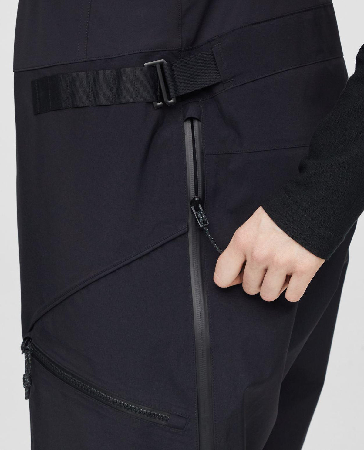 Närbild på dragkedja och detaljer på svarta Mammut Eiger Free Pro HS Bib Pants dam.