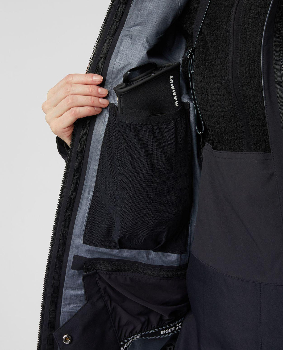 Närbild som visar innerfickan och detaljer på Mammut Eiger Free Pro HS Hooded Jacket för dam.