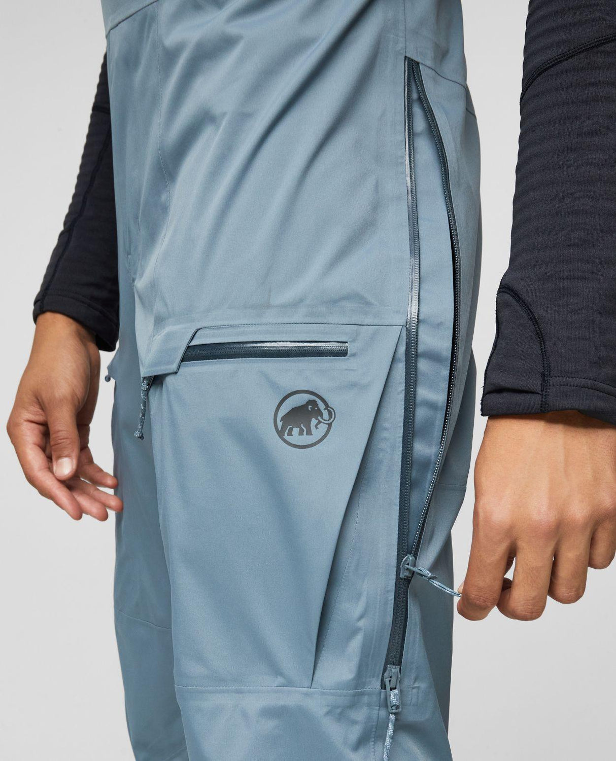 Mammut Haldigrat HS Bib Pants Men i strl 50 i färgen Strata visar fickdetaljer och ventilationsdragkedja.