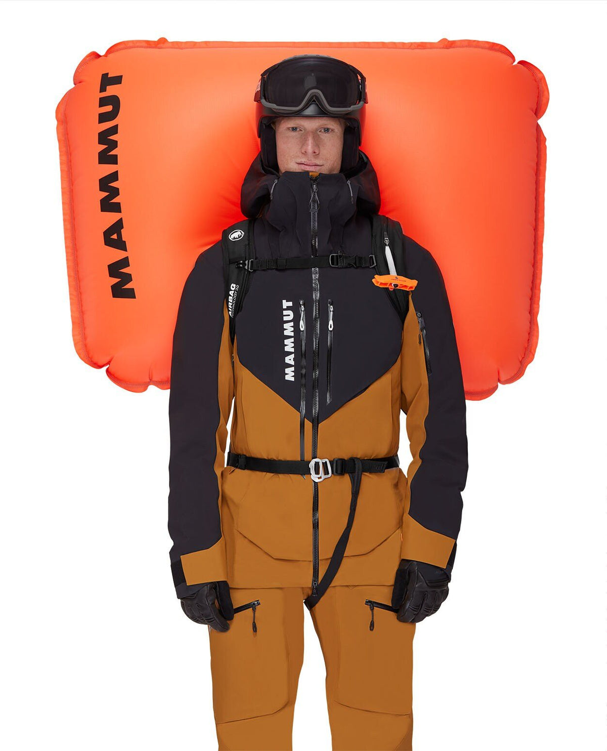 Skidåkare i svarta och bruna kläder med Mammut Free 28 lavinryggsäck och upplöst orange airbag