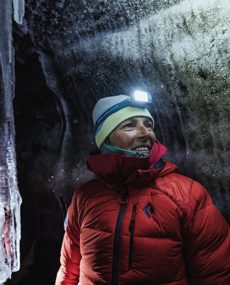 En skidåkare med Black Diamond Cosmo pannlampa i en isgrotta i fjällen.
