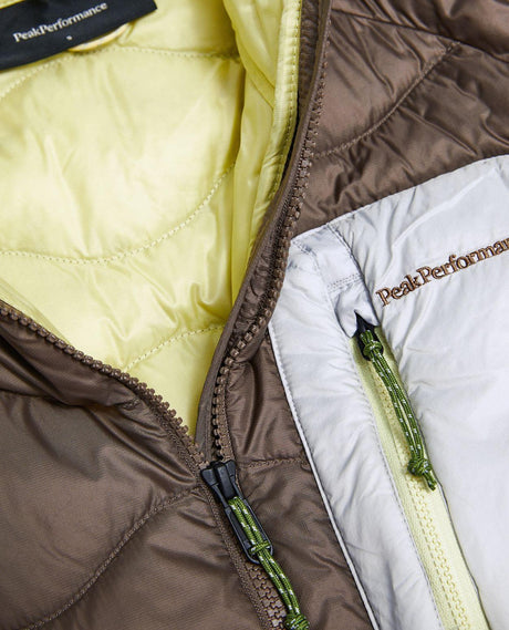 Närbild på dragkedja och bröstficka för Peak Performance Helium Utility Down Vest i Terrain Tan och Antarctica.