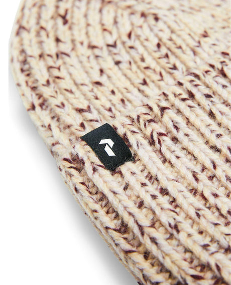Närbild på stickad mössa Peak Performance Mason Hat i färgen Alpine Harvest med svart loggolapp.