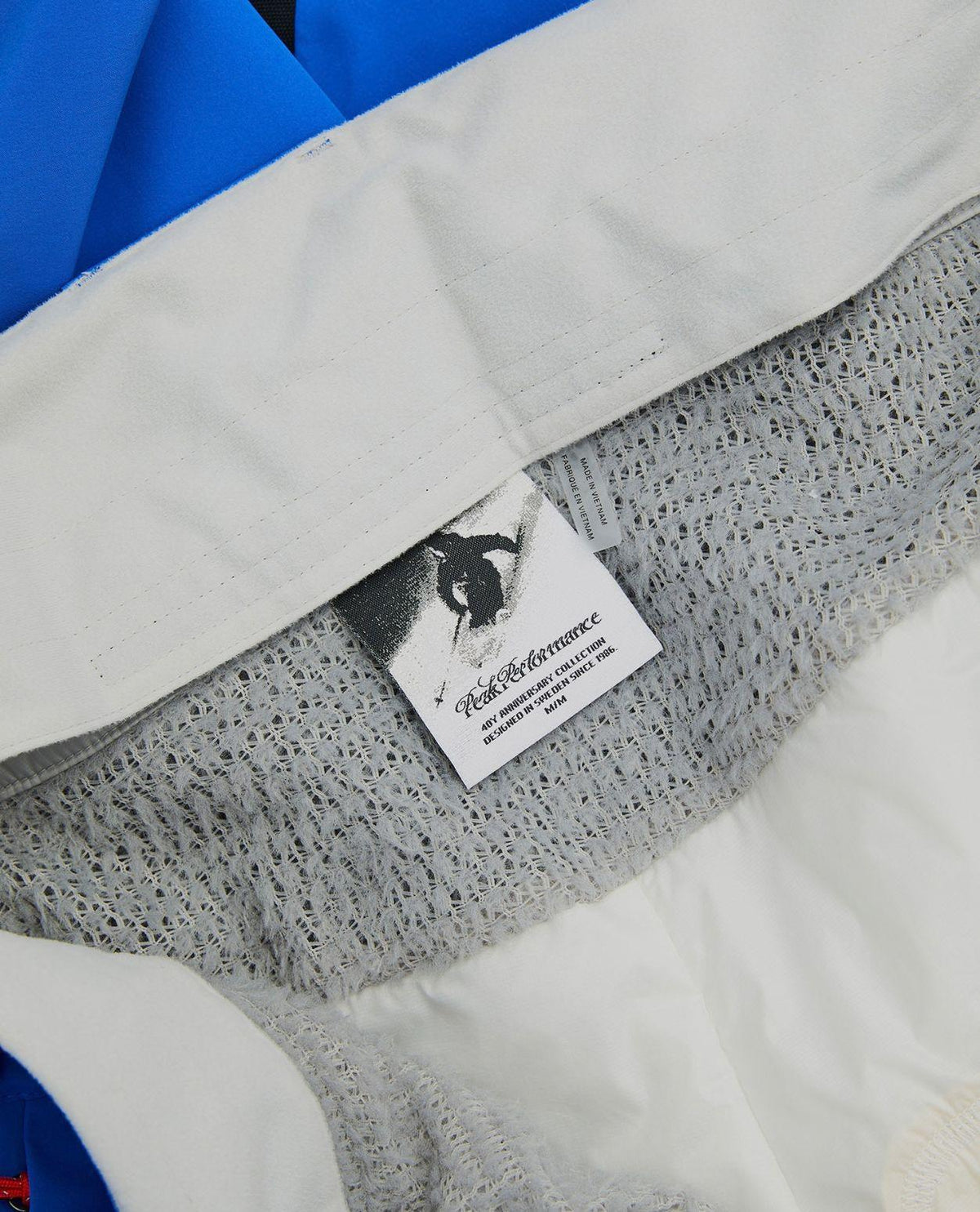 Peak Performance 40Y R&D Gore-Tex skidbyxor för herr i Ice Peak Blue, närbild på innerdetaljer och jubileumsetikett.