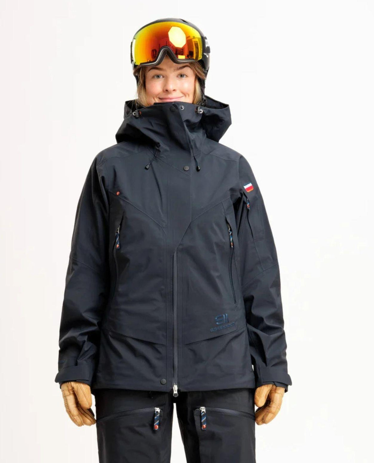 Elevenate Pure Jacket Women i mörkt blåsvart färg på skidåkare med hjälm och skidglasögon.