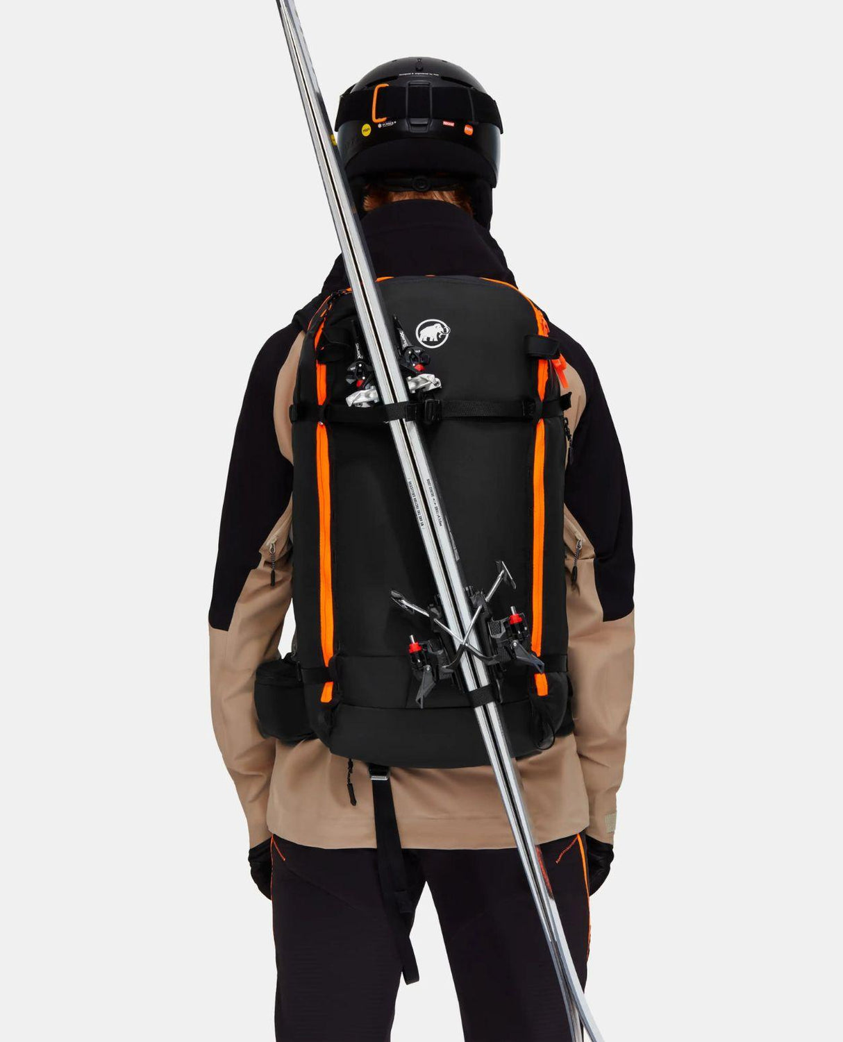 Skidåkare bakifrån som bär en svart Mammut Tour 40 Removable Airbag 3.0 med skidor fästa på utsidan.
