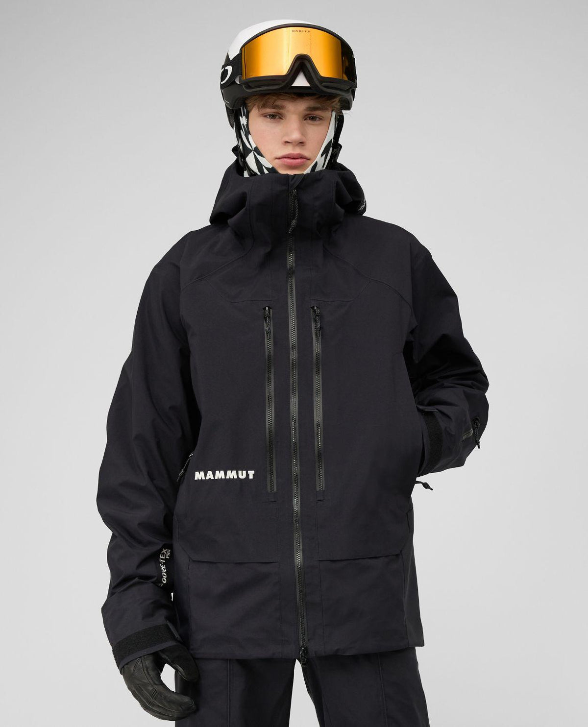 Skidåkare i svart Mammut Eiger Free Pro HS Hooded Jacket med hjälm och skidglasögon.
