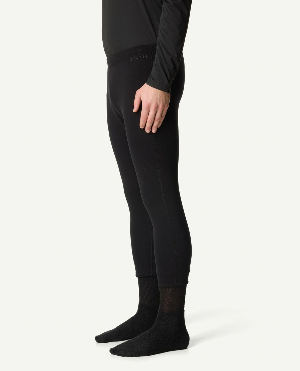 Svart underställsbyxa i modell drop knee från Houdini för herrar, visad från sidan på stående modell.