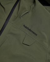 Närbild på bröstpartiet av Peak Performance Alpine Gore-Tex 3L Jacket i färgen Pine Needle med broderad logo.