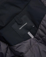 Detaljbild på innerfoder och logotyp i nackan på Peak Performance Gravity Insulated Jacket Junior i svart.