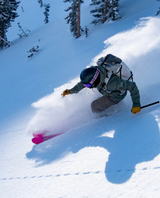 En skidåkare åker i djupt puder med DPS Pagoda Tour CFL 100 skidorna.