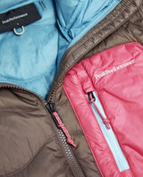 Närbild på bröstficka och dragkedja på Peak Performance Helium Utility Down Hood Jacket i dammodell.