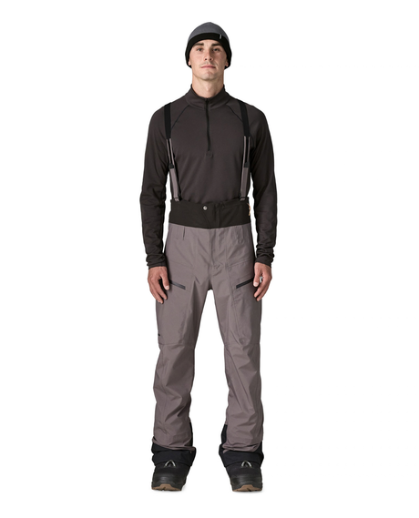 Man i grå skidbyxor av modell Patagonia PowSlayer Bibs Men i färg May Grey