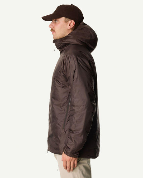 Man i profil som bär Houdini Dunfri Men i färgen Brown Illusion med luva uppfälld.