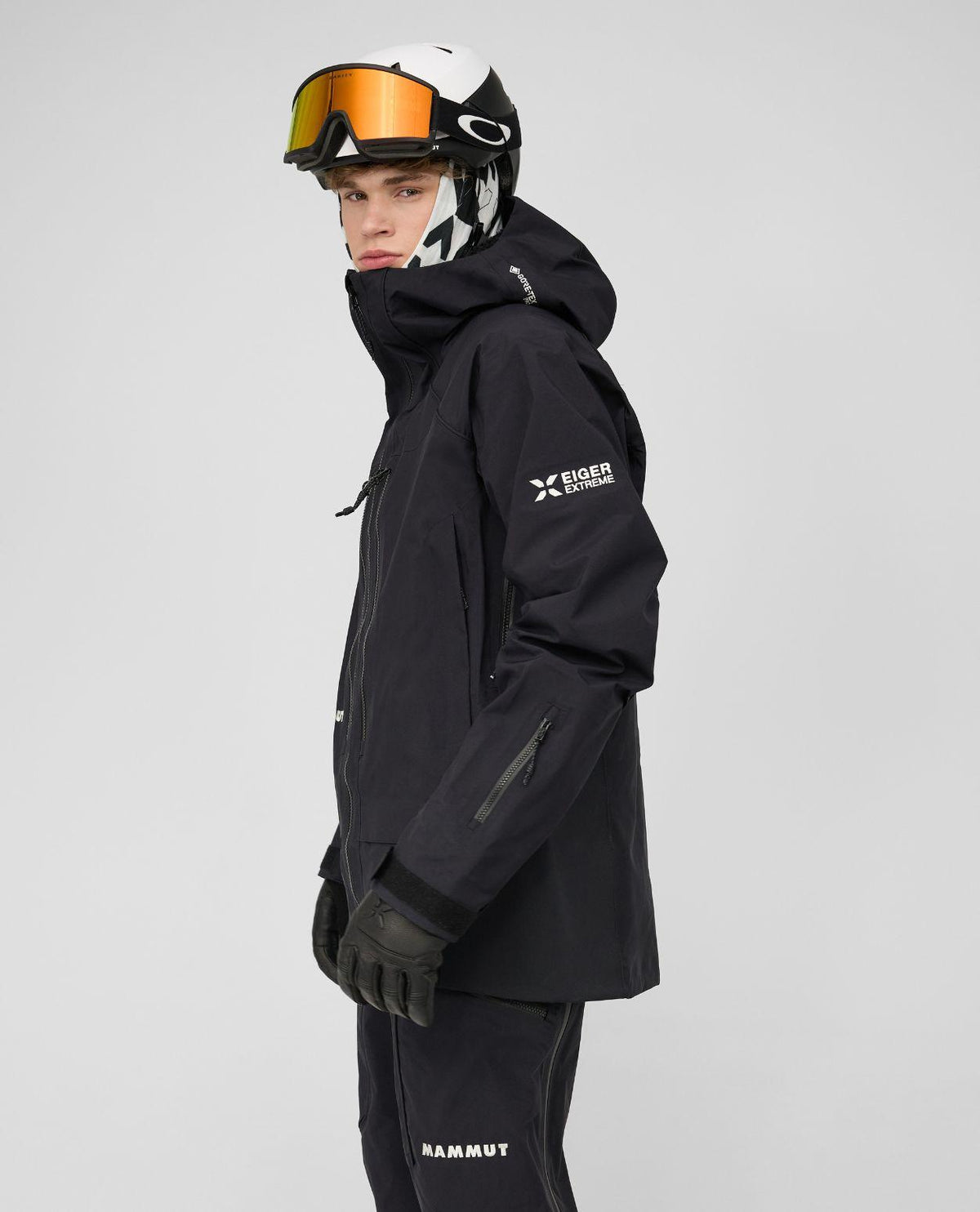 Mammut Eiger Free Pro HS Hooded Jacket i svart, bärs av en skidåkare med hjälm och skidglasögon.