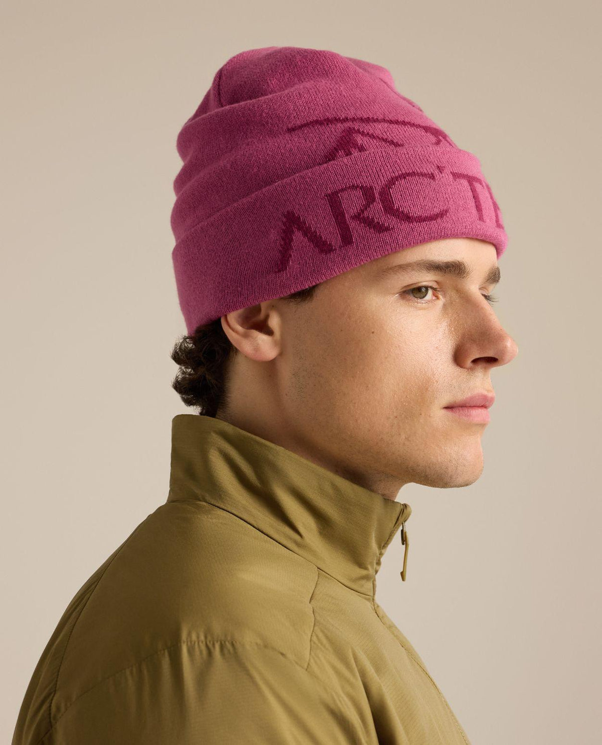 Arc'teryx Bird Word Toque i rosa färg buren av en modell, perfekt för alpina skidåkare.