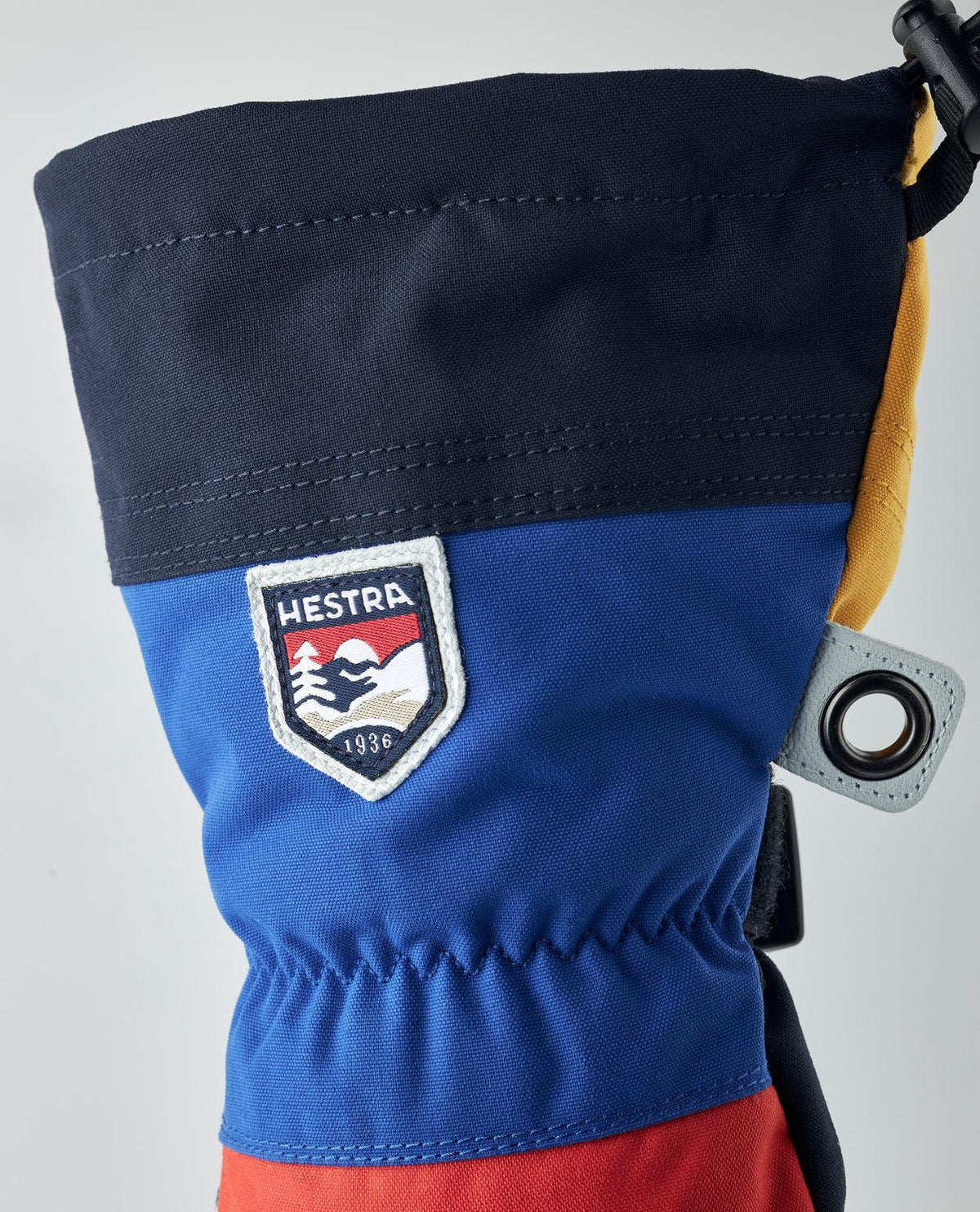 Detaljbild på kragen till Hestra Army Leather Heli Ski Mitt med Hestras logotyp och färgglada design.