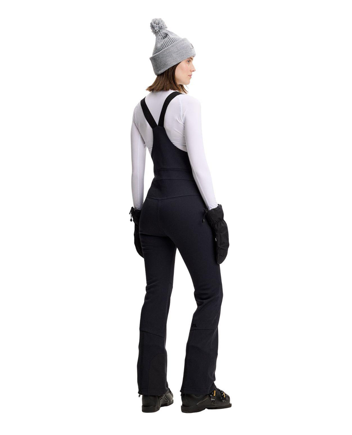J.Lindeberg Aviana Softshell Bib Pant Women i svart visad bakifrån på skidåkare.