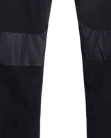Närbild som visar knäpartiets förstärkningar och detaljer på de svarta skidbyxorna J.Lindeberg Whitman Pant Men.
