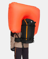 Mammut Tour 40 Removable Airbag 3.0 i svart med uppblåst orange airbagryggsäck på person.