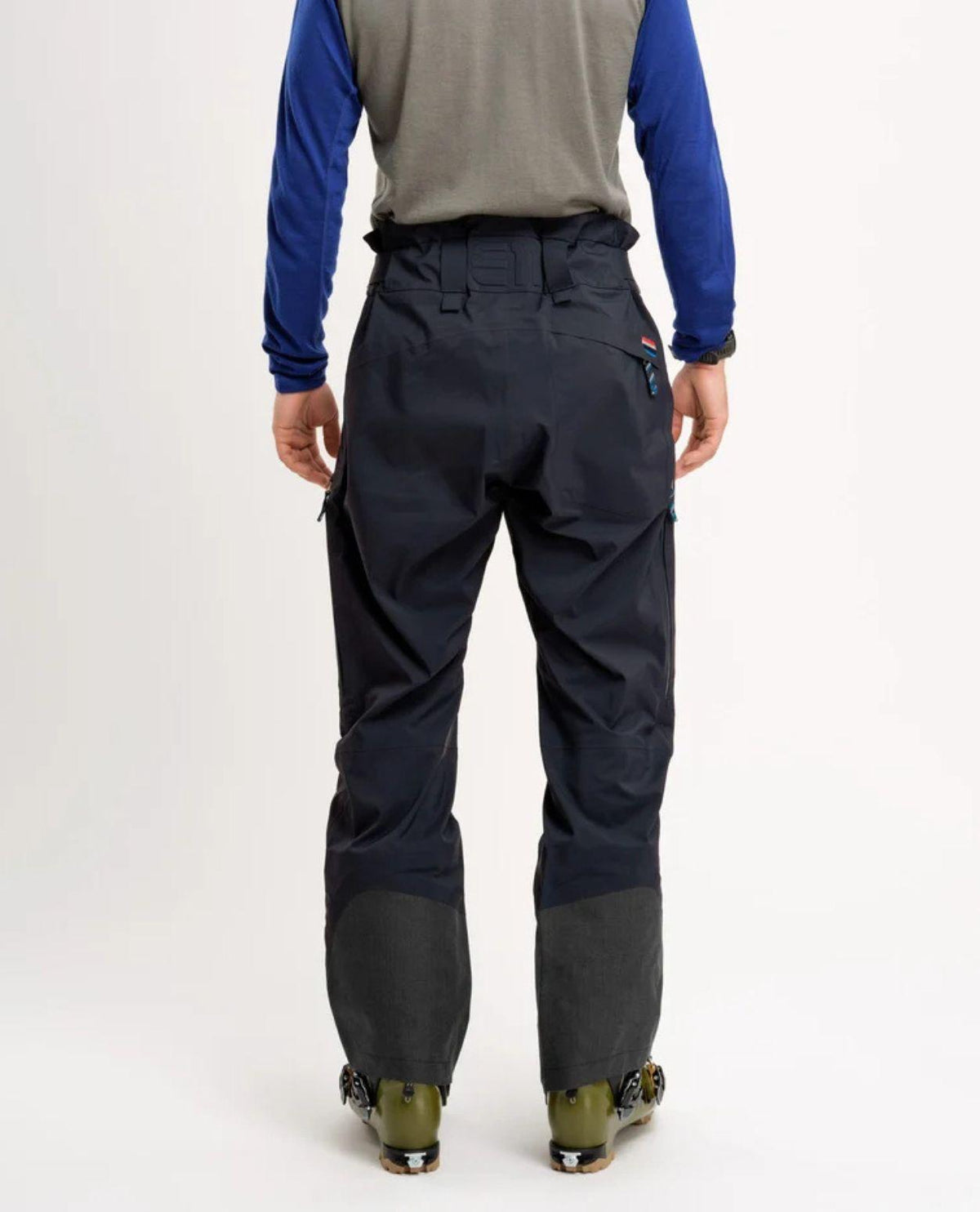Bakifrånvy av skidbyxorna Elevenate Pure Pants Men i färgen Dark Ink Solid på en skidåkare.