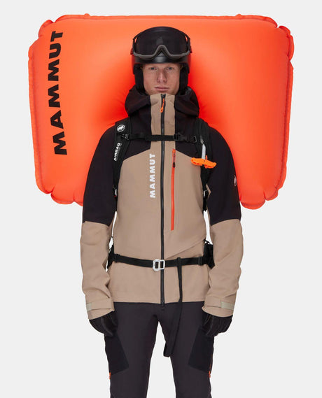 Mammut Tour 40 Removable Airbag 3.0 i svart med uppblåst orange airbag som bärs av skidåkare.