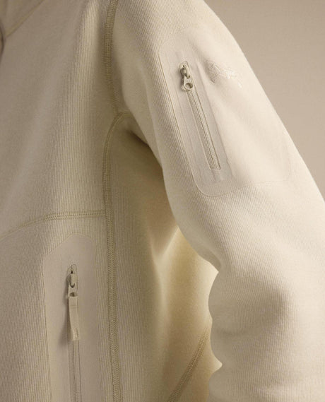 Närbild på ärmficka och detaljer på Arc'teryx Covert 1/2 Zip damtröja i färg Arc Silk Hthr/Salt.