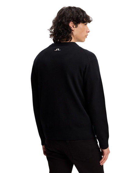 Man i svart J.Lindeberg William Knitted Sweater sett bakifrån mot vit bakgrund.