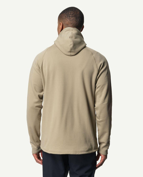 Man bakifrån iförd en grön hoodie från Houdini med huva och långa ärmar.