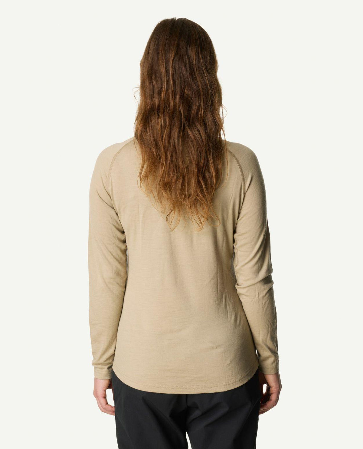 Kvinna sedd bakifrån iförd Houdini Puremerino Halfzip i färgen powder green.