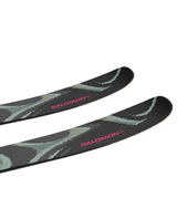 Salomon QST 100 allmountainskidor med svart design och rosa Salomon-logotyp på topparna.