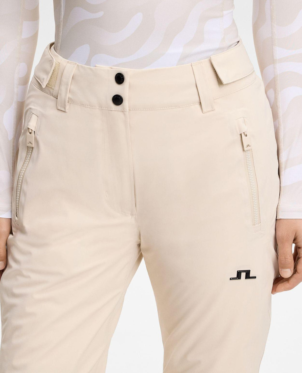 J.Lindeberg Elara Pant Women - Moonbeam skidbyxor i beige dammodell som visar midja, knappar och fickor.