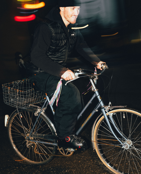 Skidåkare som cyklar i mörker iklädd svarta Atomic Hawx Prime 130 S BOA alpinpjäxor med rött BOA-vred.