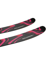 Salomon QST 106 svarta och rosa friåkningsskidor, närbild på skidlarna med tydlig logotyp i snömiljö.