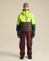 Arc'teryx Sabre Bib Men skidbyxor i lila färg på modell tillsammans med skidjacka och mössa.