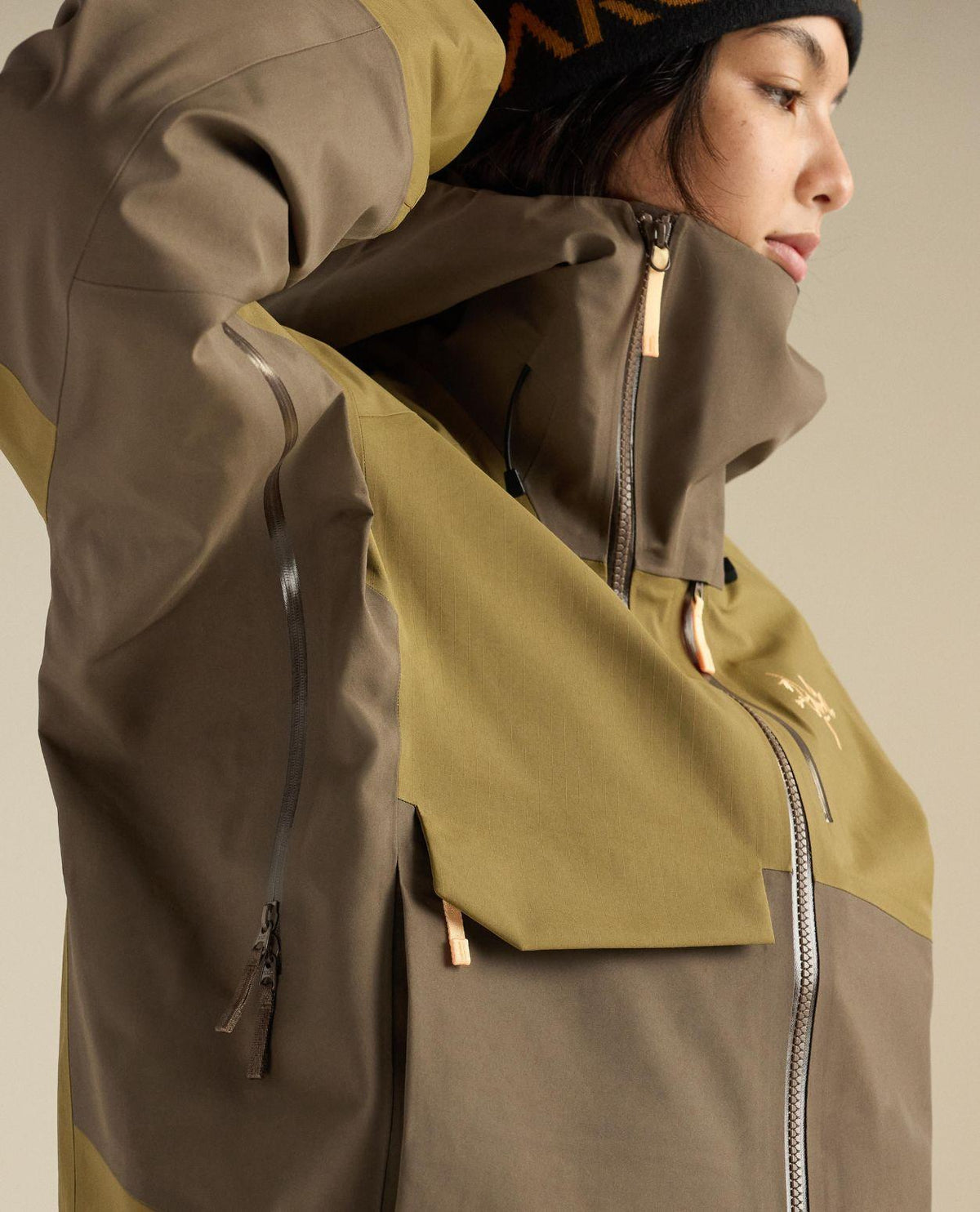 Arc'teryx Sidewinder Jacket dam i brun färg, med fokus på GORE-TEX Pro-materialets krage och ärmdetaljer.