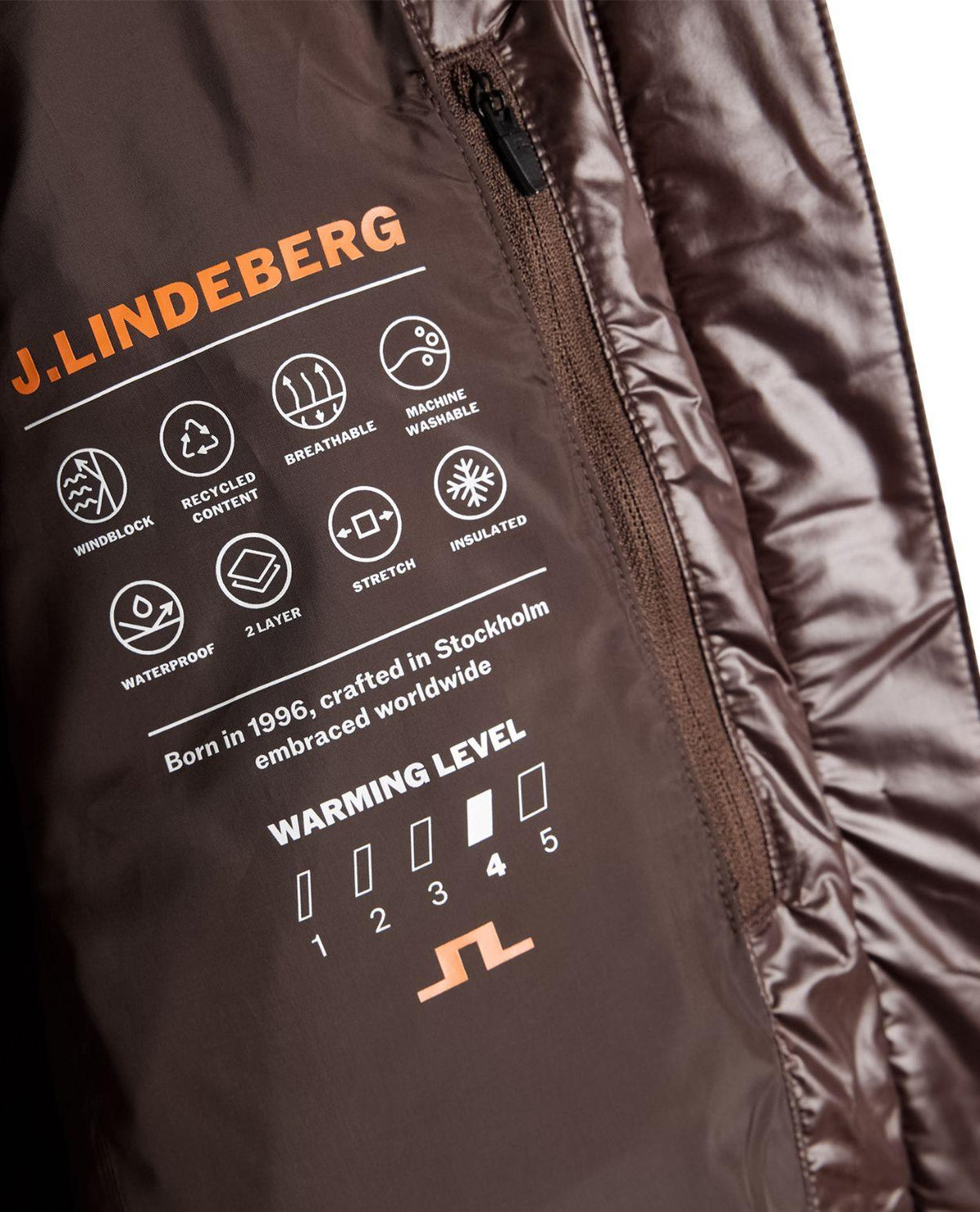 J.Lindeberg Nerina Down Jacket Women i brun färg med fokus på innerfoder och tekniska ikoner. - Alpingaraget